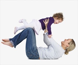 Mother lifting daughter into air. Date : 2008