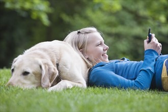 Girl resting on dog in park. Date : 2008