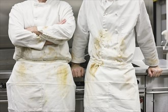 Dirty chefs leaning against stove. Date : 2008