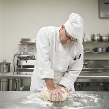 Baker kneading bread dough. Date : 2008