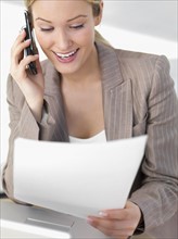 Businesswoman discussing paperwork on cell phone. Date : 2008