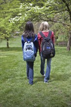 Girls with backpacks walking in park. Date : 2008