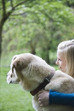 Girl hugging dog in park. Date : 2008