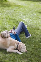 Girl leaning on dog in park. Date : 2008