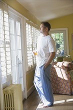 Man in pajamas looking out window. Date : 2008