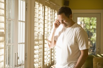 Man talking on cell phone in livingroom. Date : 2008