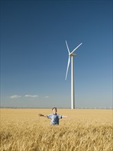 Boy running through field on wind farm. Date : 2008