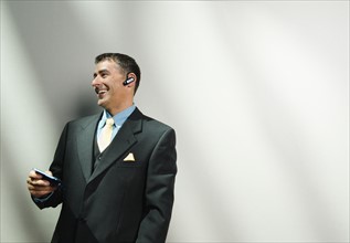 Businessman using cell phone and hands-free device. Date : 2008