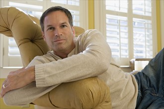 Man relaxing in arm chair. Date : 2008
