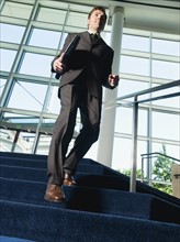 Businessman descending office building stairs. Date : 2008