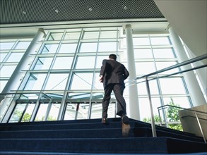Businessman ascending office building stairs. Date : 2008
