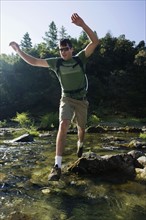Man jumping across river on rocks. Date : 2008