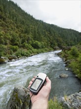 Man holding gps unit by river. Date : 2008