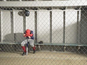 Sad baseball player sitting in dugout. Date : 2008