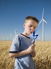 Boy holding pinwheel on wind farm. Date : 2008