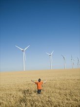 Boy standing in field on wind farm. Date : 2008