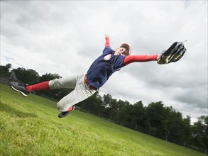 Baseball player diving to catch ball. Date : 2008