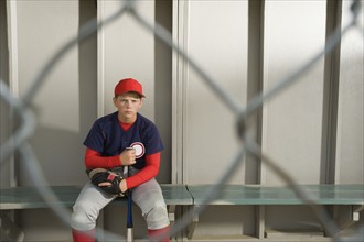 Serious baseball player sitting in dugout. Date : 2008