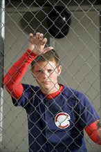 Serious baseball player standing in dugout. Date : 2008