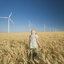 Girl looking to sky on wind farm. Date : 2008