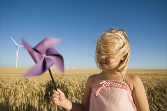 Girl holding pinwheel on wind farm. Date : 2008