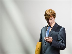 Businessman looking at cell phone. Date : 2008