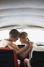 Young couple sitting in van on beach. Date : 2008