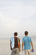 Young men walking on beach. Date : 2008
