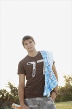 Teenage boy carrying beach towel on shoulder. Date : 2008