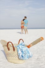 Young couple and beach essentials on beach. Date : 2008