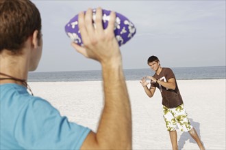Friend playing football on beach. Date : 2008