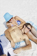 Young couple leisurely sunbathing on beach. Date : 2008