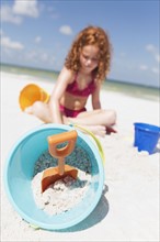 Girl digging in sand on beach. Date : 2008