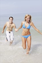Young couple running in ocean. Date : 2008