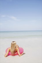 Teenage girl sitting in inflatable ring in shallow ocean. Date : 2008