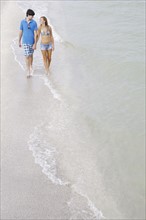 Teenage couple walking in ocean. Date : 2008