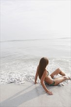 Teenage girl sitting in ocean. Date : 2008