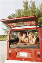 Teenage couple relaxing in van on beach. Date : 2008