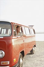 Teenage girl sitting in van on beach. Date : 2008