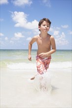 Boy running in ocean. Date : 2008