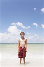 Boy standing in ocean. Date : 2008