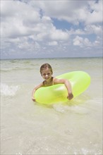 Girl playing in inflatable ring into ocean. Date : 2008