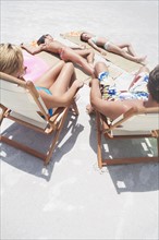 Family sunbathing on beach. Date : 2008