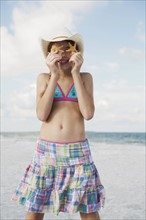Girl on beach holding starfish. Date : 2008