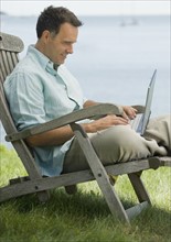 Man working on laptop outdoors.