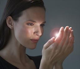 Light shining from woman’s hands.