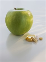 Close up of green apple and vitamins.