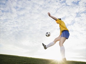 Teenage girl kicking soccer ball. Date : 2008