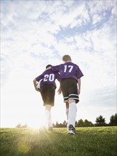 Boys in soccer uniforms walking on field. Date : 2008