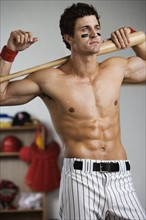 Baseball player with bare chest posing in locker room. Date : 2008